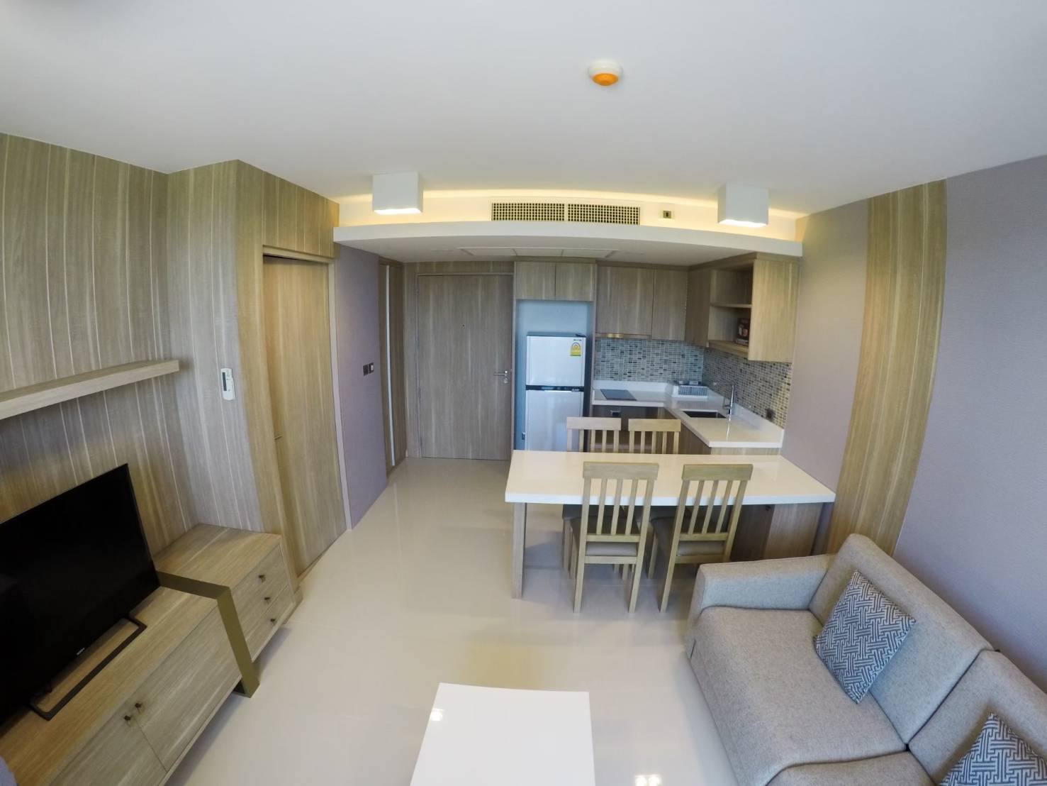 Furnished open-plan living room, dining area and kitchen in The Pine Hua Hin condominium