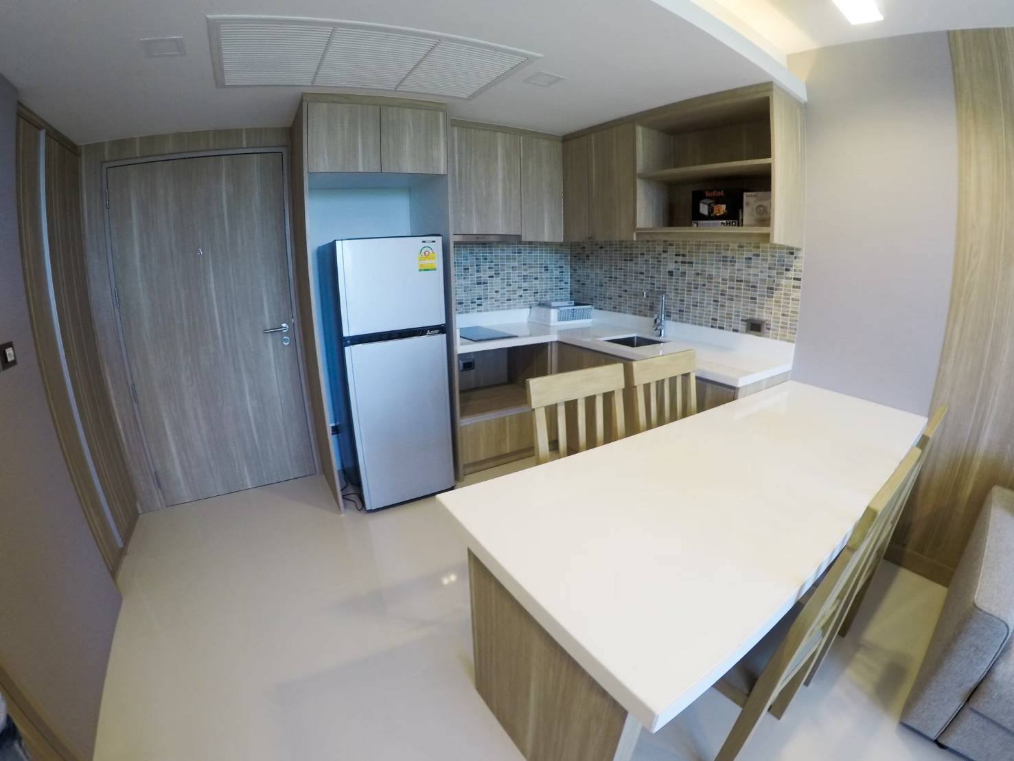 Modern fitted kitchen with refrigerator and dining counter at The Pine Hua Hin